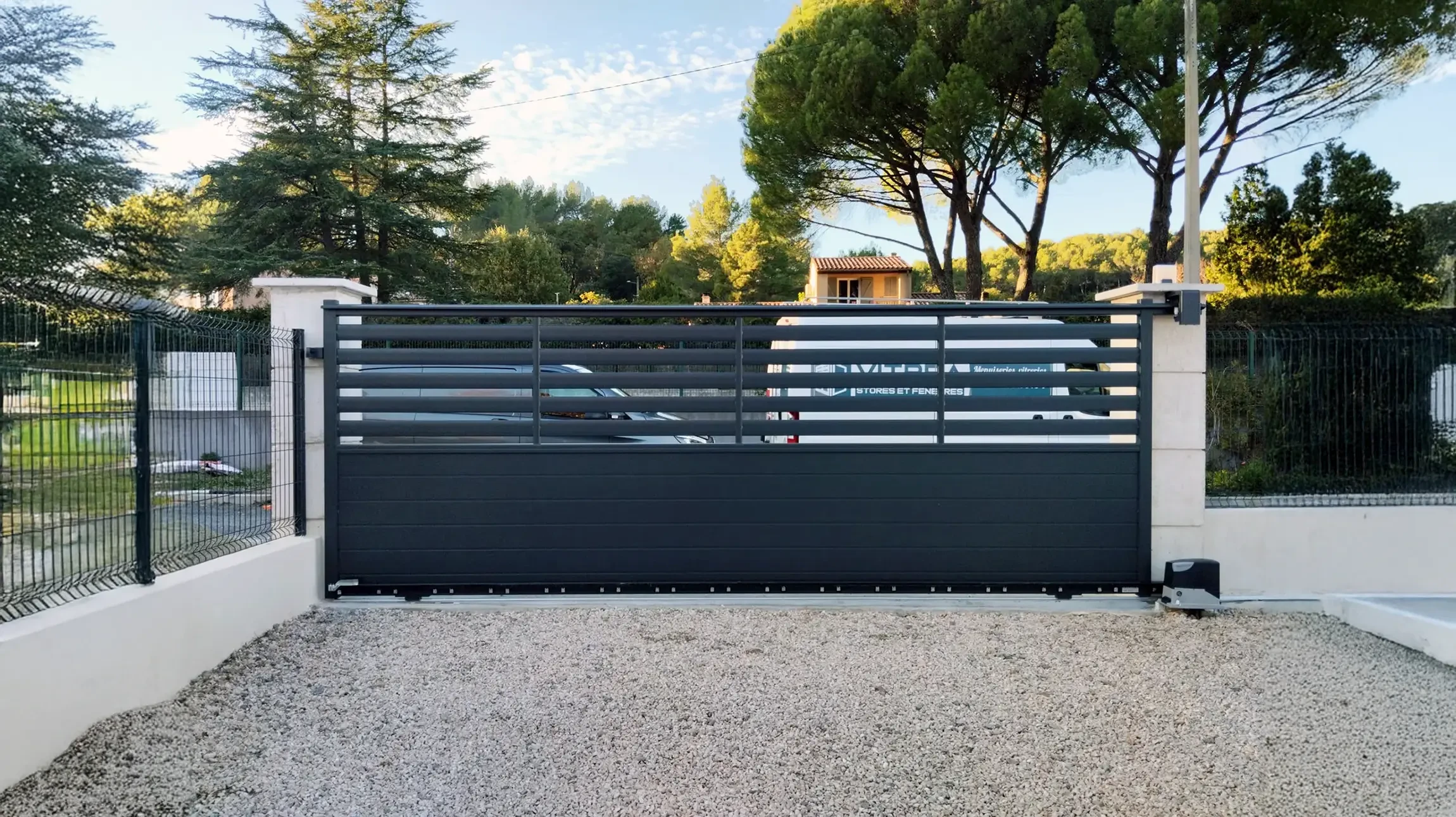 Terrasse couverte moderne avec grandes baies vitrées coulissantes donnant sur jardin paysagé